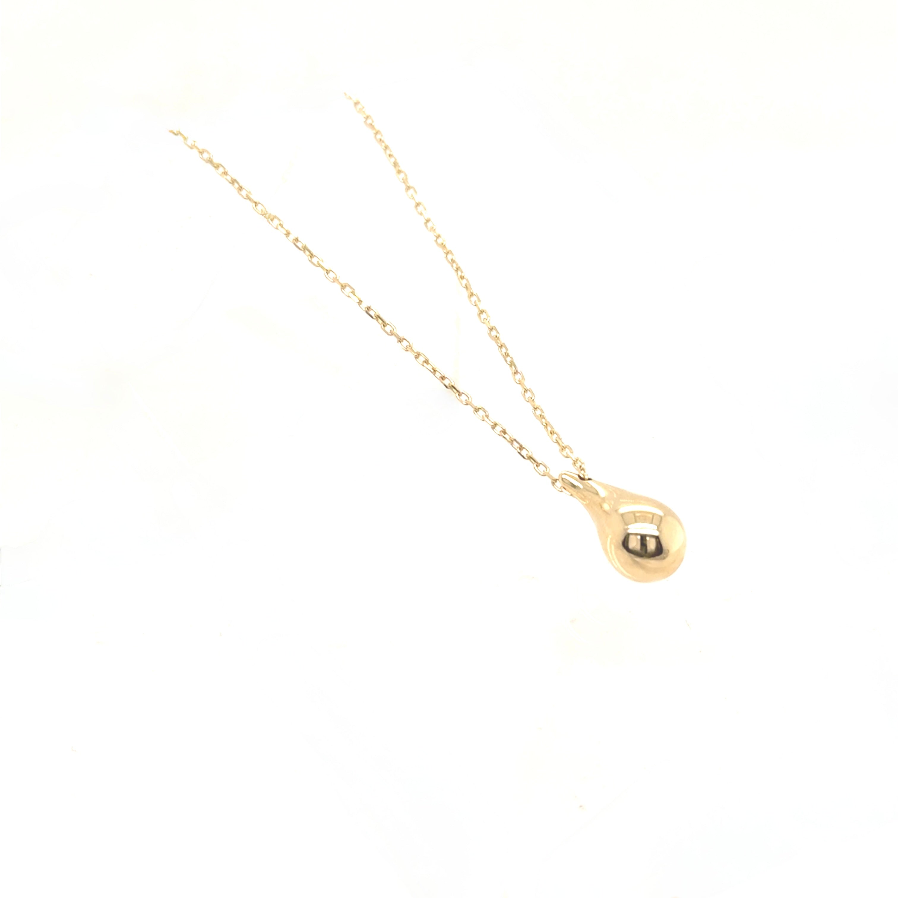 Gold necklace with a teardrop pendant on a white background
